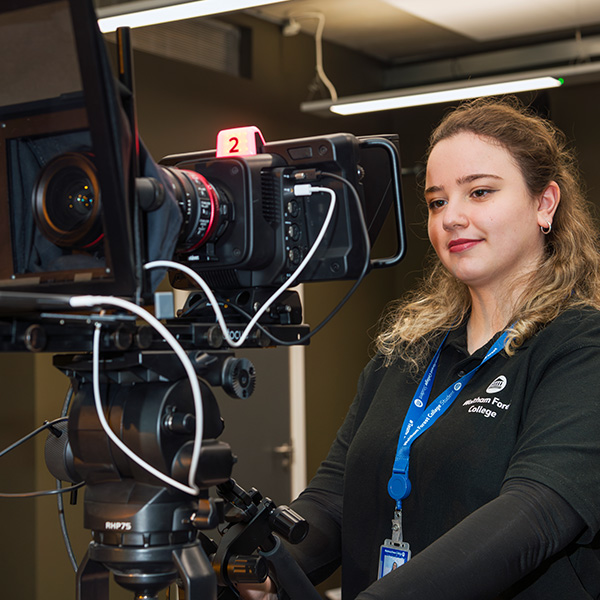 Media student operating video recording equipment