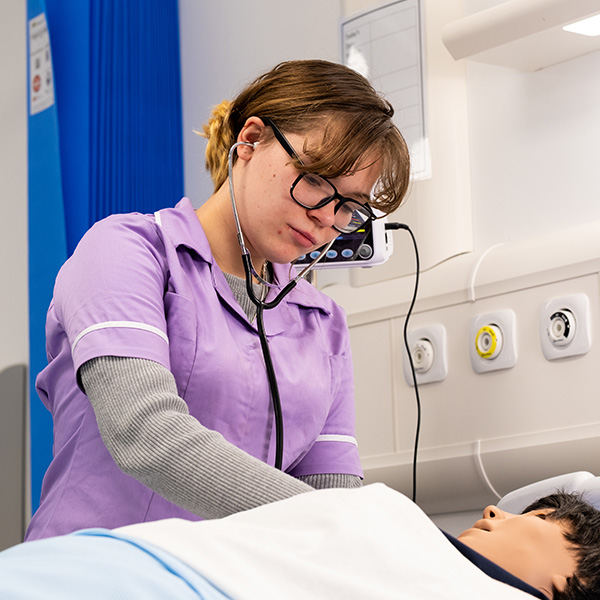 Healthcare student tending a dummy patient