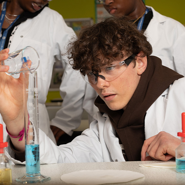 Science student mixing chemicals in a lab